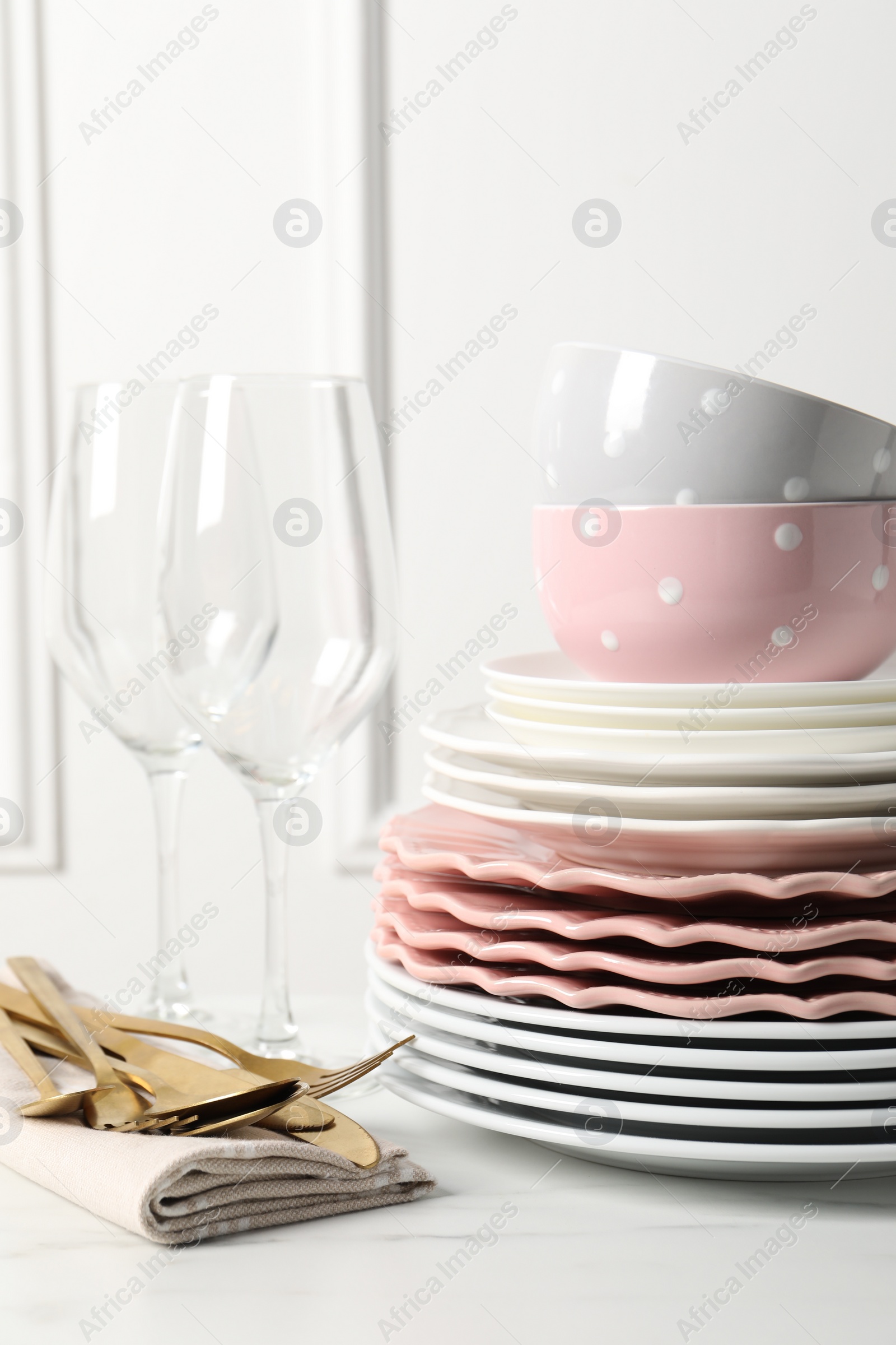 Photo of Beautiful ceramic dishware, glasses and cutlery on white marble table