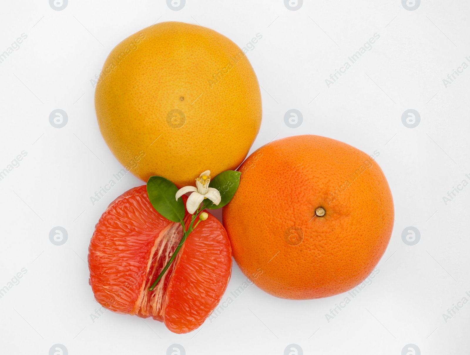 Photo of Fresh grapefruits and green leaves on white background, top view