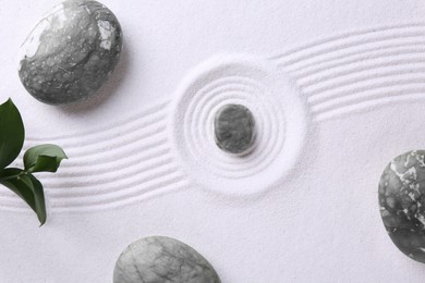 Photo of Zen concept. Stones, leaves and pattern on white sand, flat lay