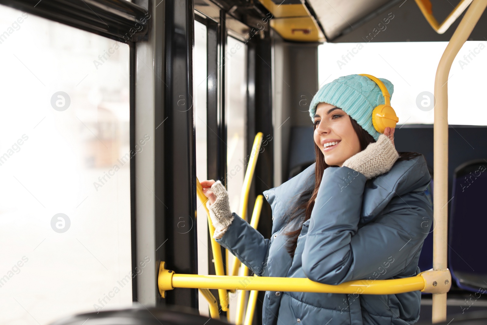 Photo of Young woman listening to music with headphones in public transport