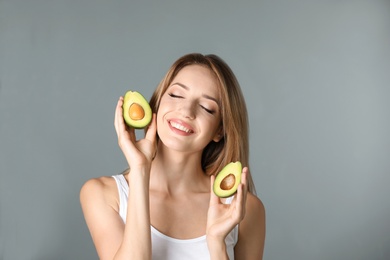 Photo of Portrait of young beautiful woman with ripe delicious avocado on color background