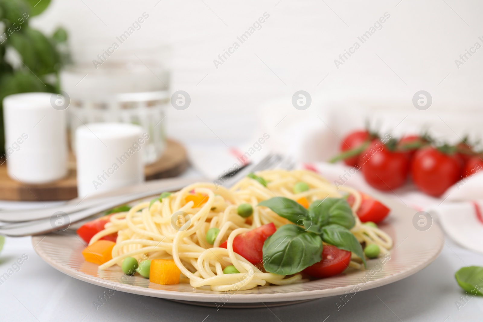 Photo of Plate of delicious pasta primavera served on white table, closeup