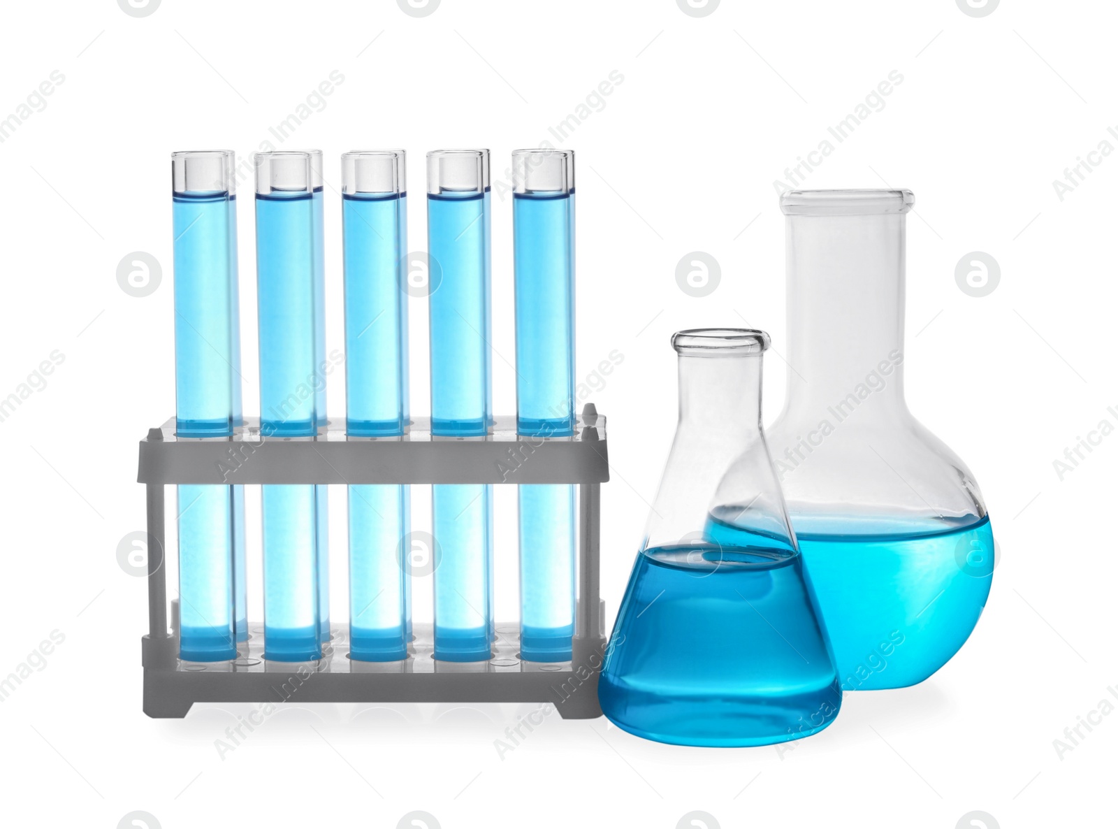 Photo of Different laboratory glassware with light blue liquid on white background