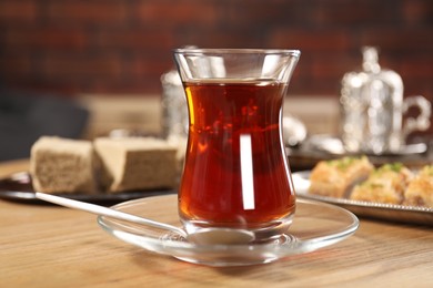 Traditional Turkish tea in glass on wooden table, closeup