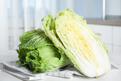 Photo of Whole and cut fresh ripe Chinese cabbages on white table