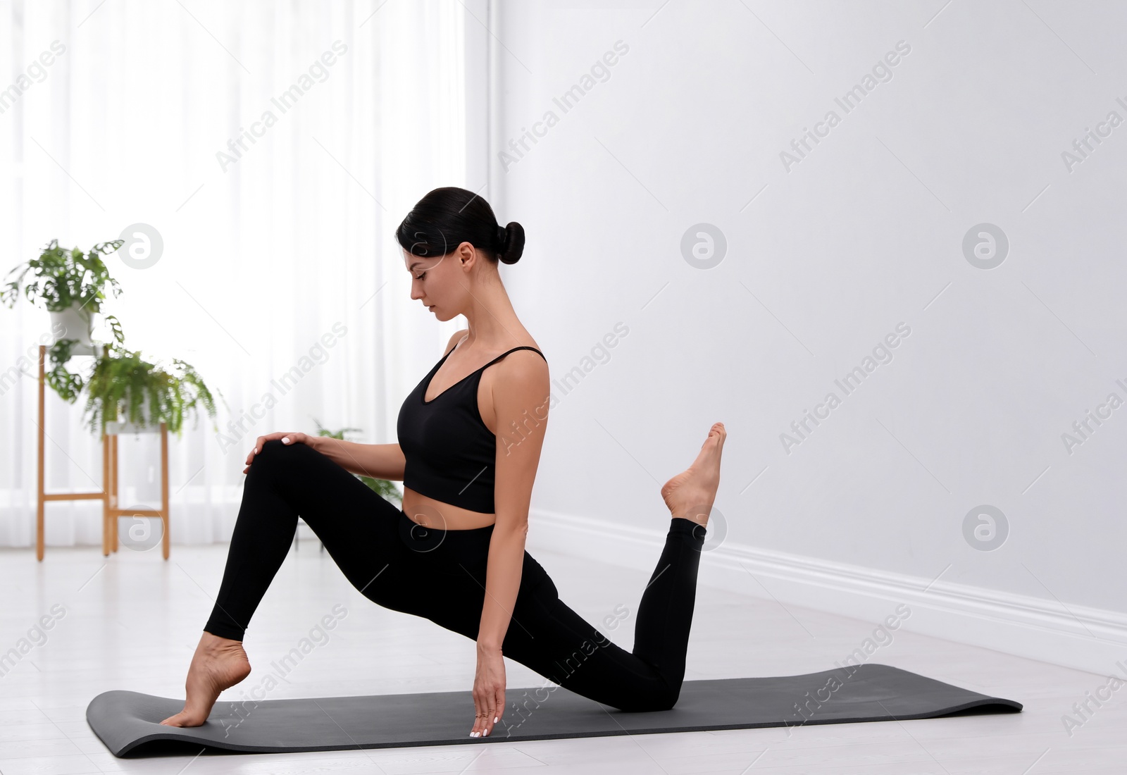 Photo of Professional young acrobat practicing yoga at home