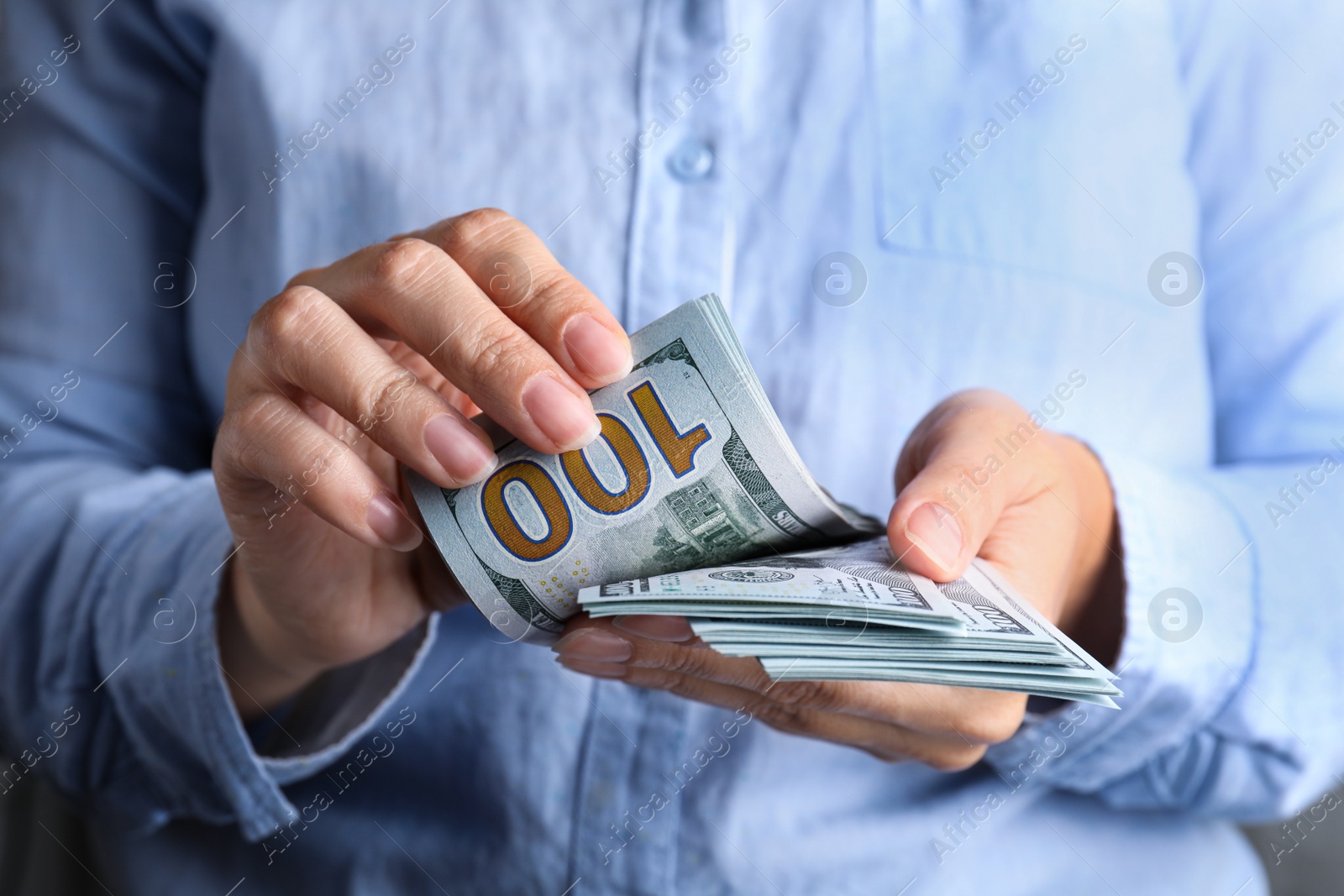 Photo of Woman holding stack of dollar banknotes, closeup