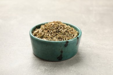 Fennel seeds in bowl on grey table