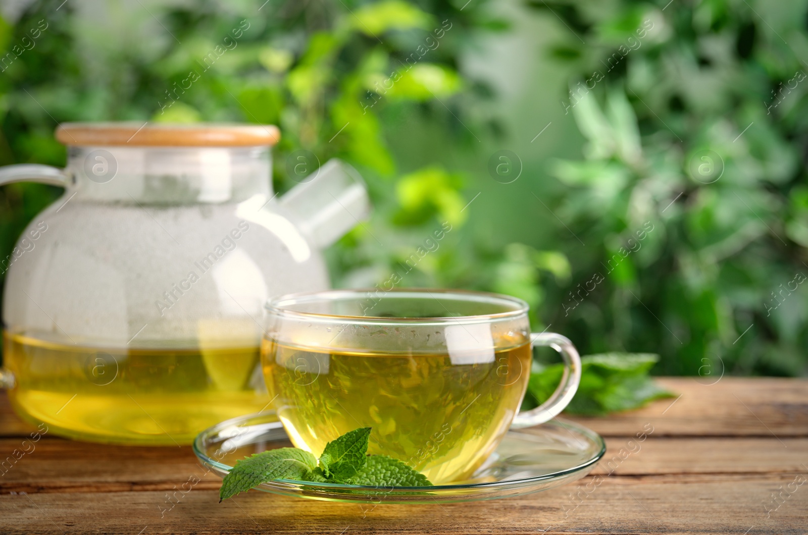 Photo of Fresh green tea with mint on wooden table