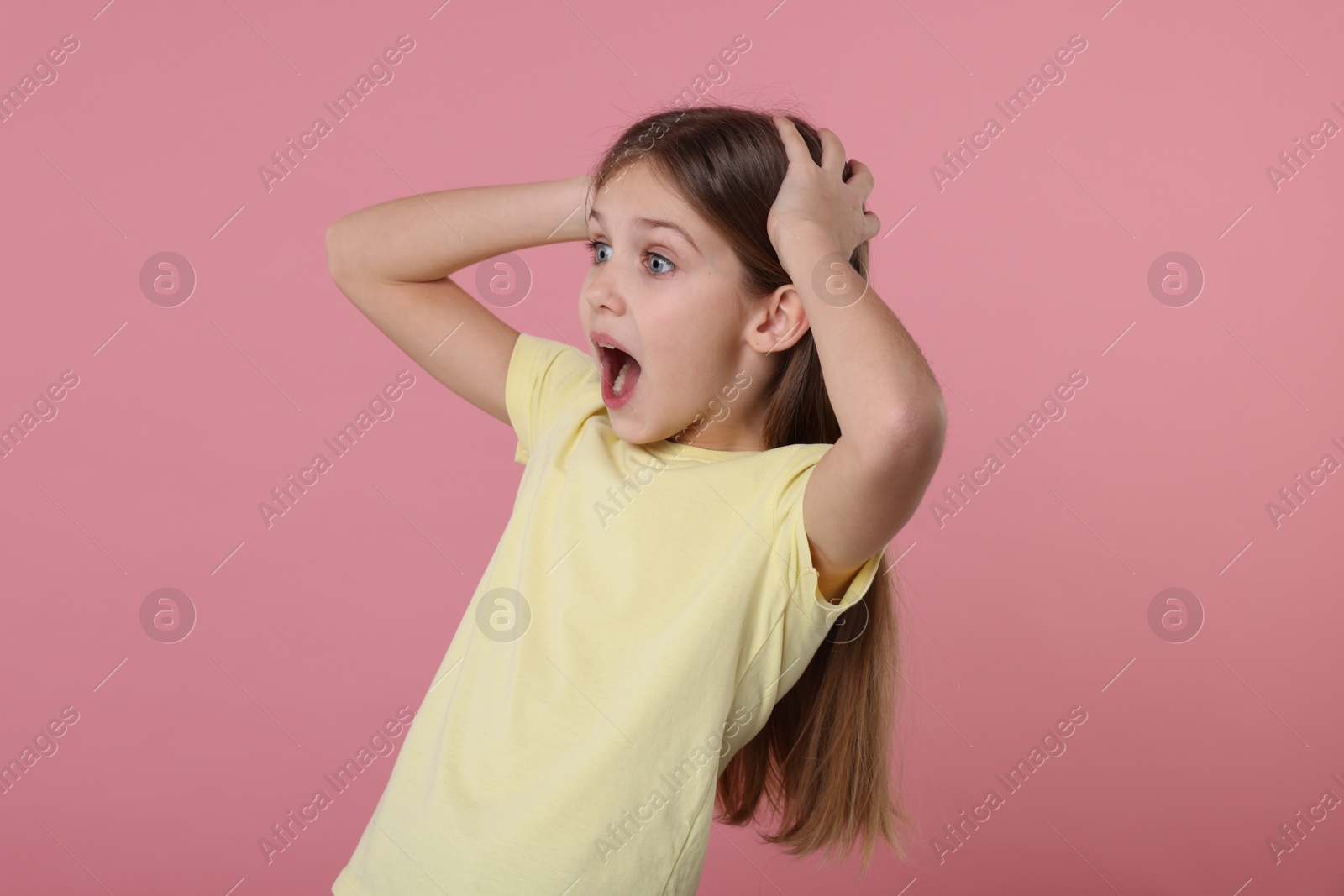 Photo of Portrait of surprised girl on pink background