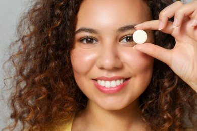 African-American woman with vitamin pill, closeup view