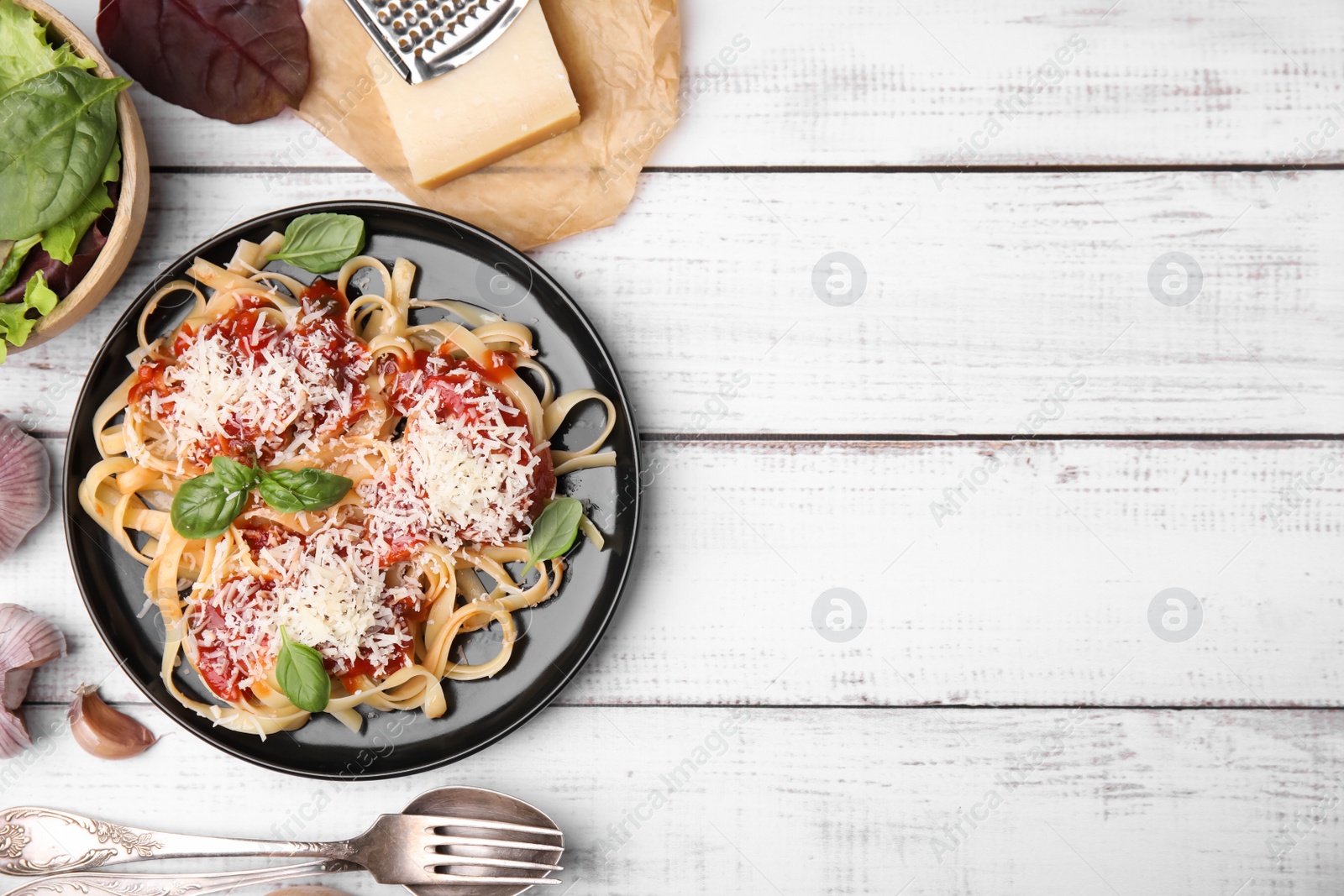 Photo of Delicious pasta with tomato sauce, basil and parmesan cheese on white wooden table, flat lay. Space for text