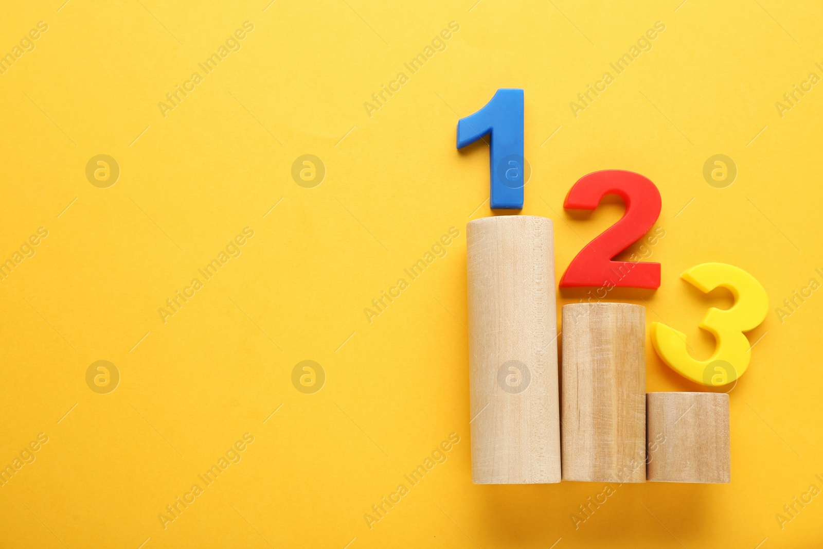 Photo of Numbers on wooden blocks against pale orange background, top view with space for text. Competition concept