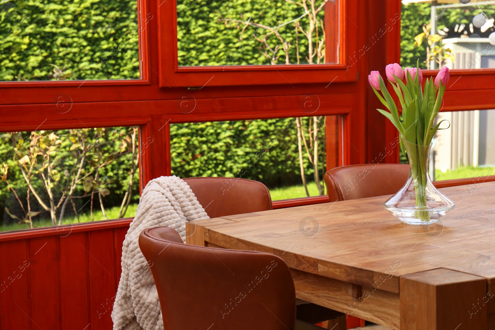 Photo of Wooden table and chairs with blanket on terrace