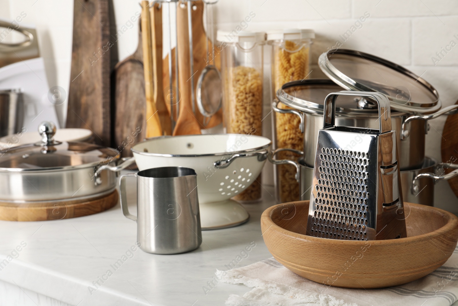 Photo of Different cooking utensils and raw pasta on countertop in kitchen