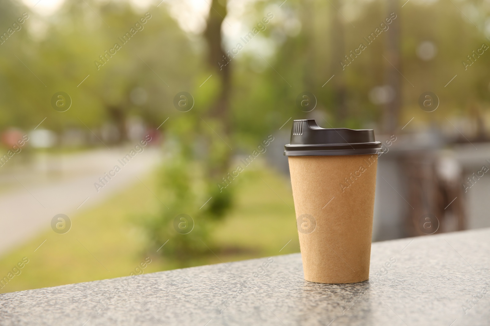 Photo of Takeaway paper coffee cup outdoors, space for text