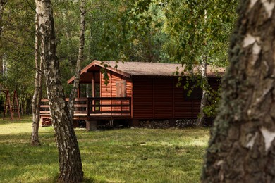 Beautiful wooden summer house among trees outdoors