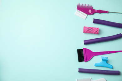 Photo of Professional tools for hair dyeing on light blue background, flat lay. Space for text