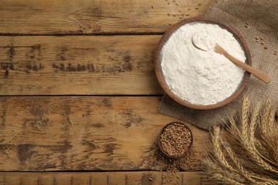 Photo of Flat lay composition with wheat flour on wooden table. Space for text