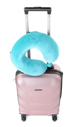 Photo of Light blue travel pillow on suitcase against white background