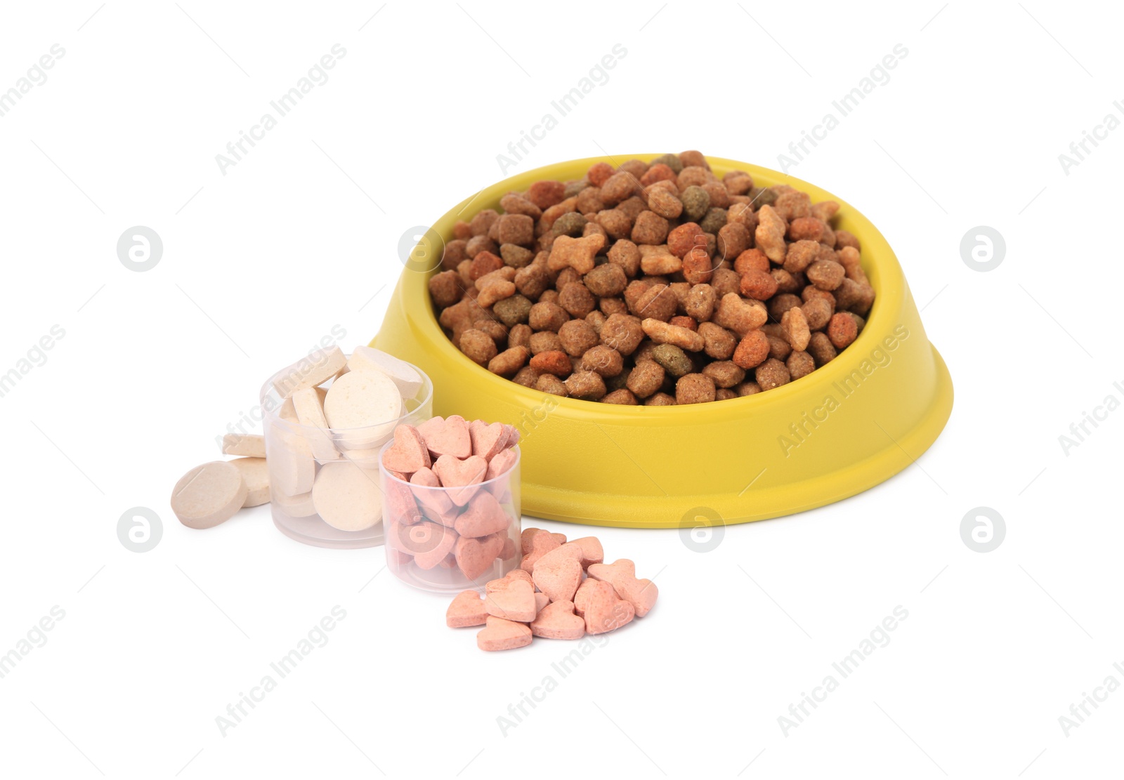 Photo of Dry pet food in bowl and vitamins isolated on white