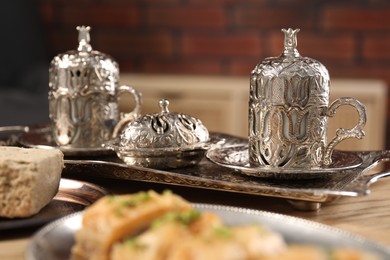 Photo of Turkish tea and sweets served in vintage tea set on table, closeup