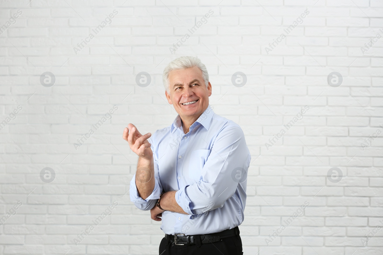 Photo of Portrait of handsome mature man near brick wall