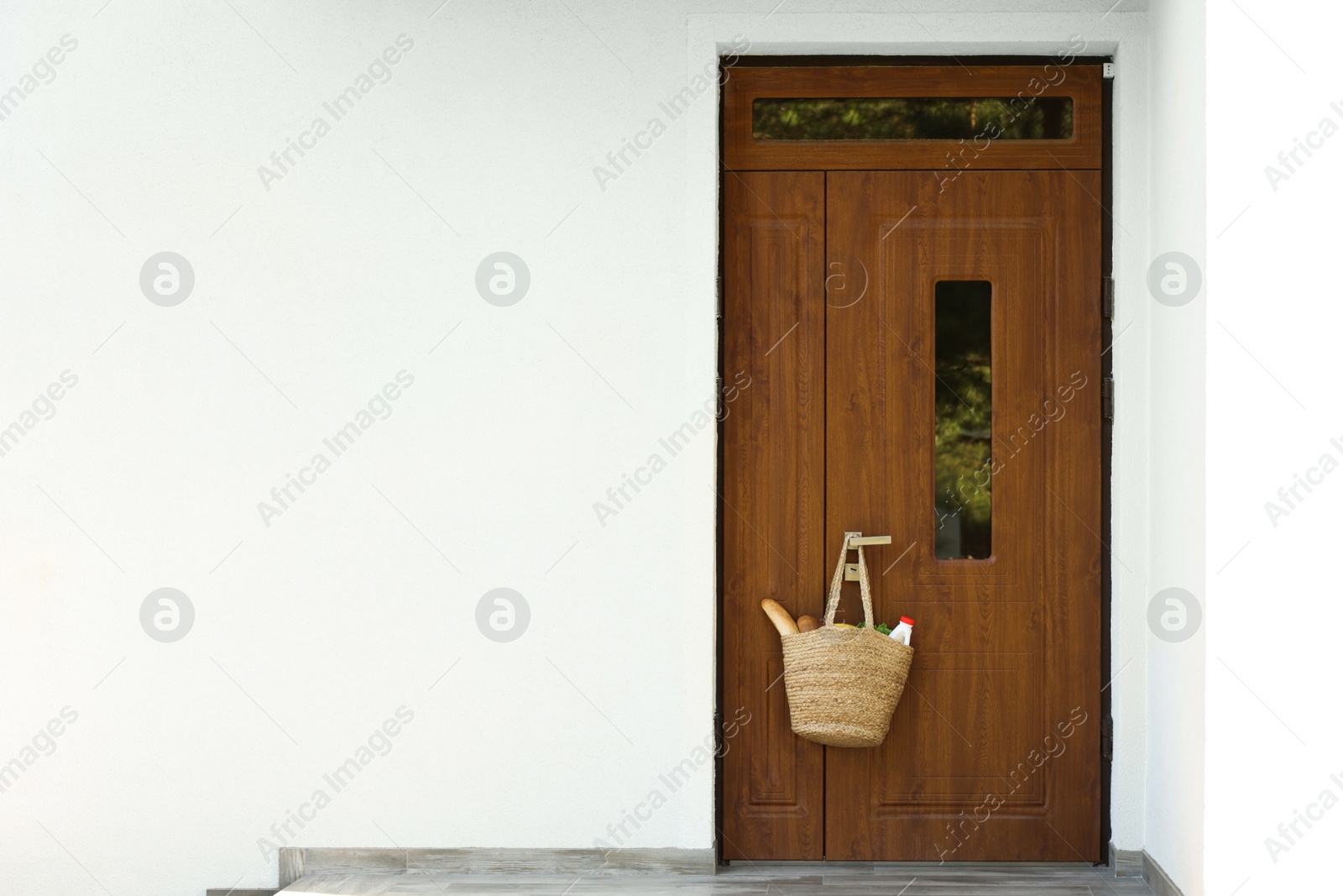 Photo of Helping neighbours. Bag of products hanging on door outdoors