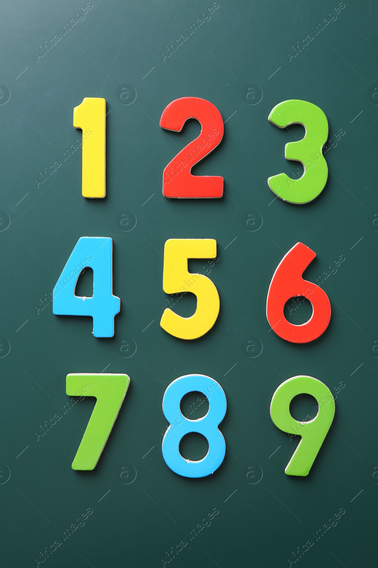 Photo of Colorful numbers on green background, flat lay