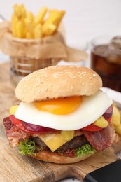 Photo of Delicious burger with fried egg on table, closeup