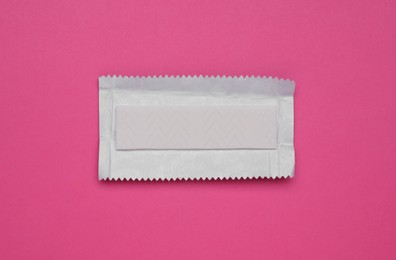 Unwrapped stick of tasty chewing gum on bright pink background, top view