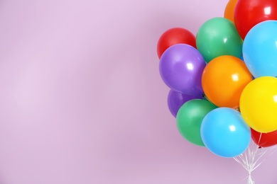 Photo of Bunch of bright balloons and space for text against color background