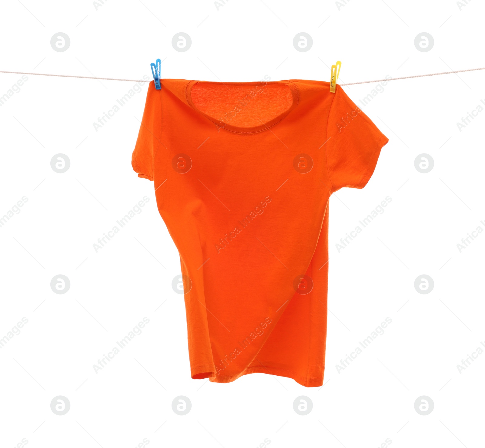 Photo of One orange t-shirt drying on washing line isolated on white