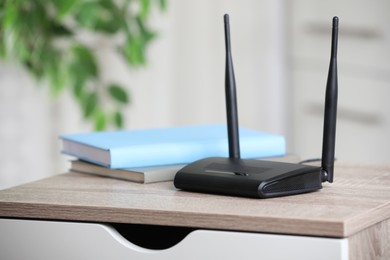 Photo of Modern Wi-Fi router indoors. Space for text