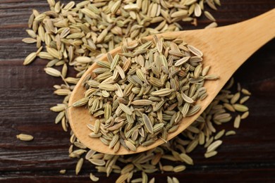 Photo of Spoon with fennel seeds on wooden table, top view
