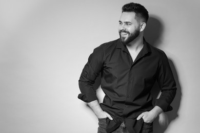 Portrait of handsome bearded man on light background. Black and white effect