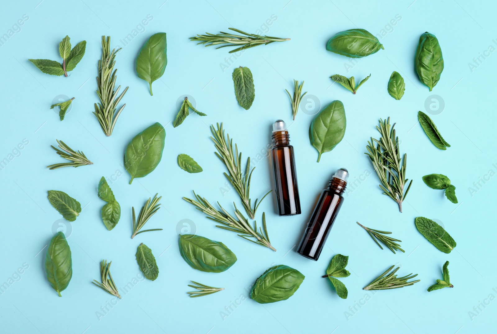 Photo of Flat lay composition with herbal essential oils on light blue background