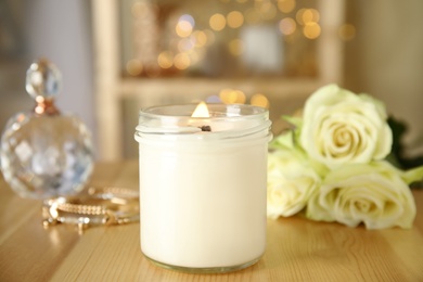 Photo of Burning candle in glass holder on wooden table