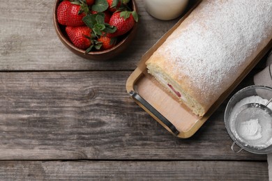 Photo of Delicious sponge cake roll with strawberries and cream on wooden table, flat lay. Space for text