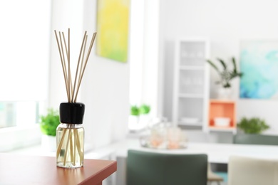 Photo of Aromatic reed air freshener on table in room