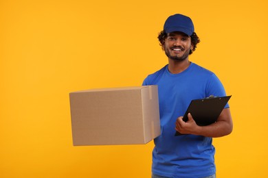 Happy courier with parcel and clipboard on orange background