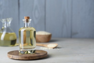 Sesame oil in glass bottle on light grey table. Space for text