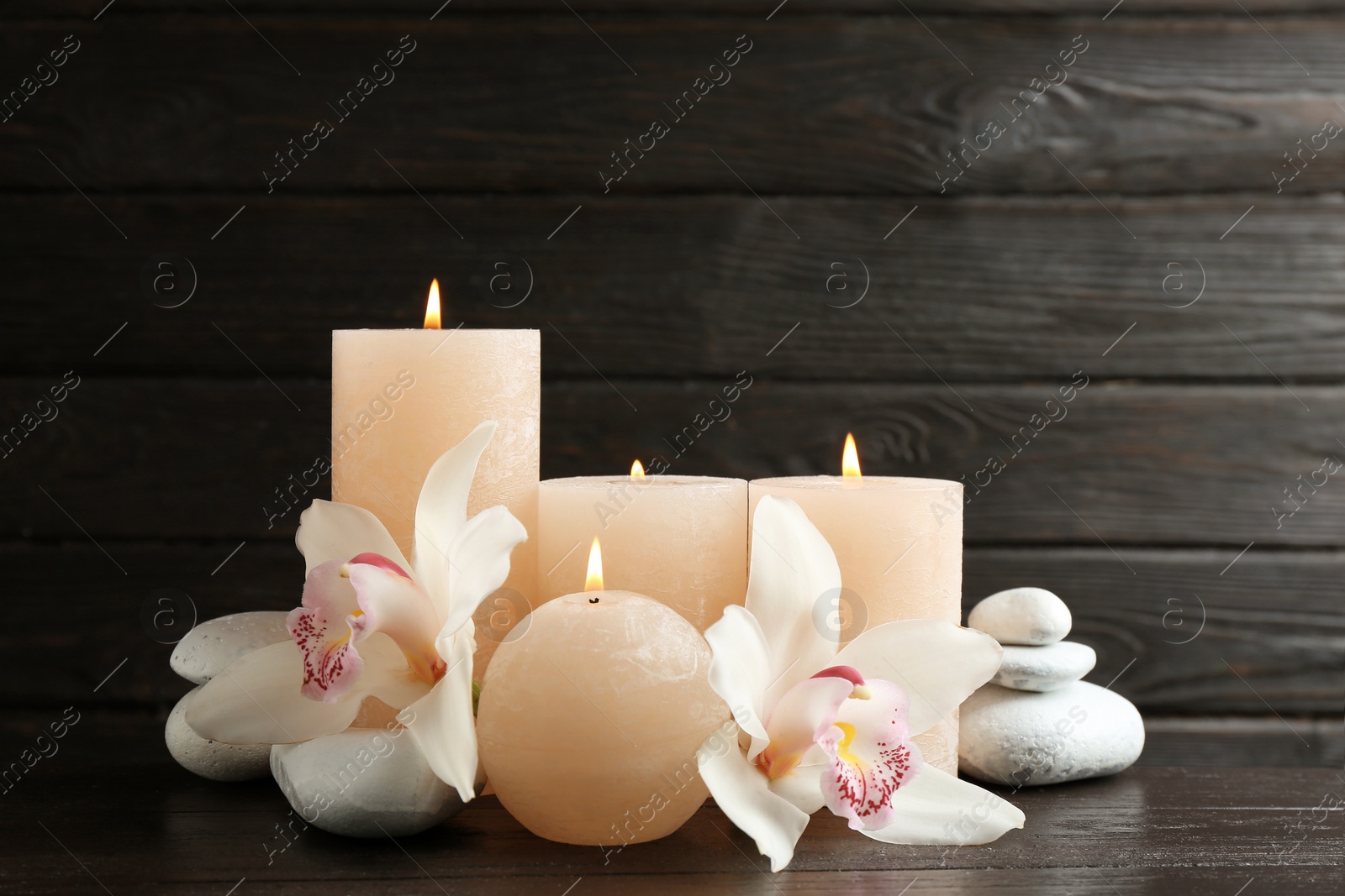 Photo of Beautiful composition with lit candles and flowers on table