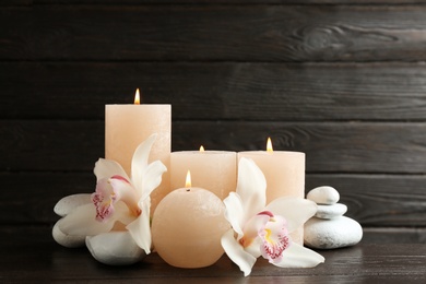 Photo of Beautiful composition with lit candles and flowers on table