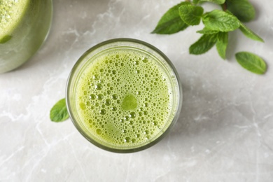 Photo of Glass with delicious detox juice and mint on light background, top view