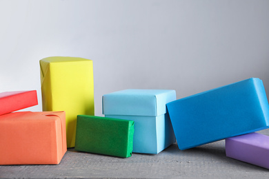 Photo of Bright boxes on grey table. Rainbow colors