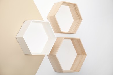 Empty honeycomb shaped shelves on color wall