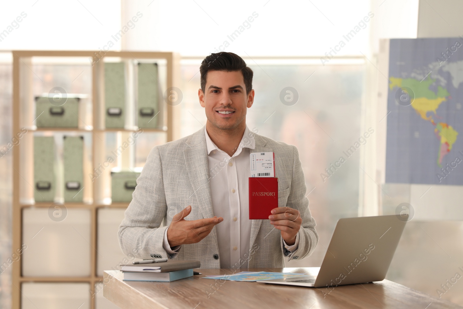 Photo of Travel agent with ticket and passport in office