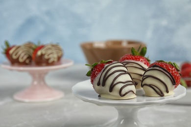 Photo of Dessert stand with chocolate covered strawberries on table, closeup