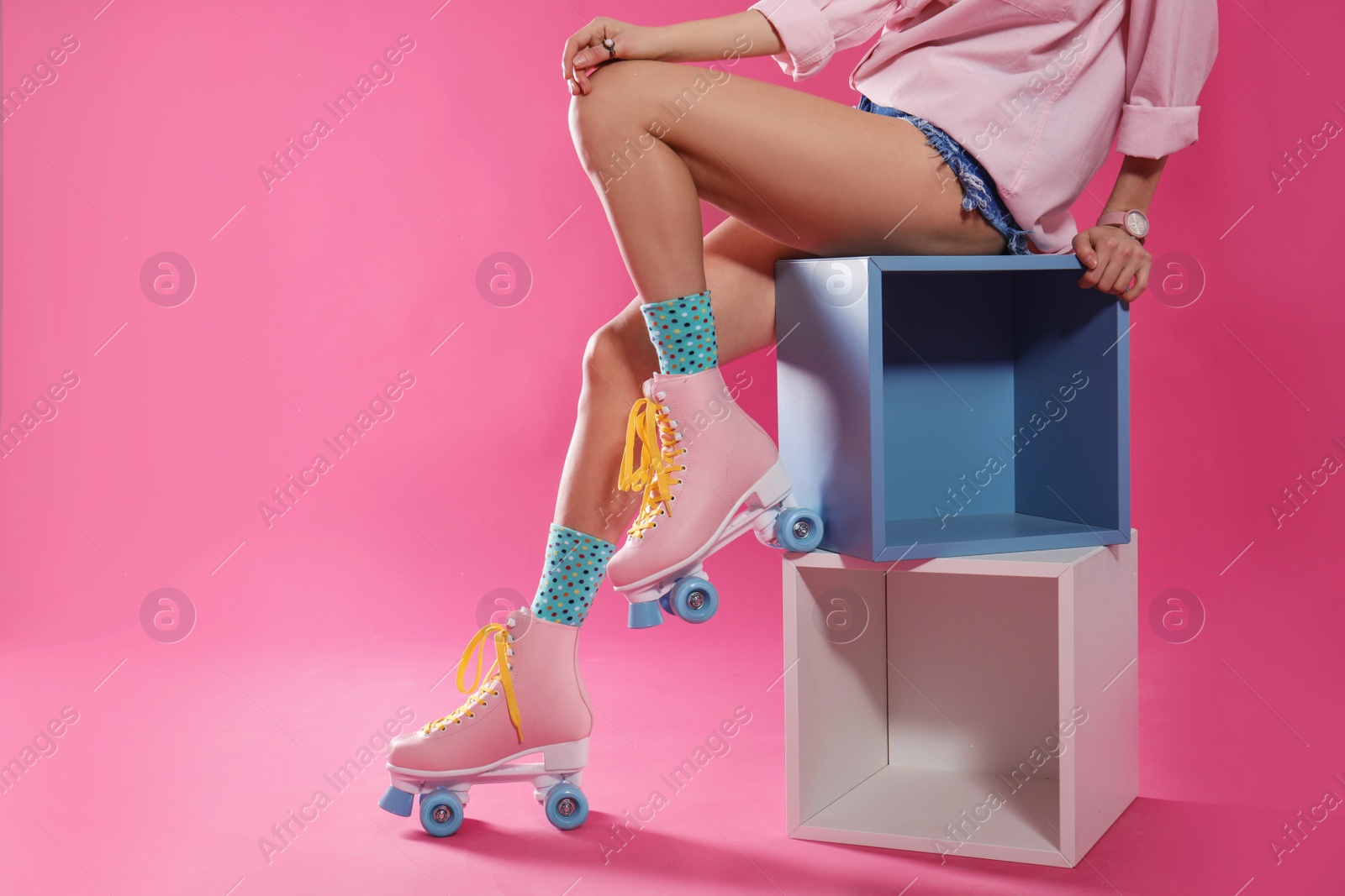 Photo of Young woman with retro roller skates on color background, closeup. Space for text